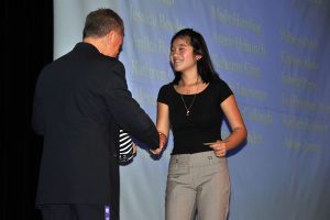 One of the advisors greets a student on stage after she announced her project. 
