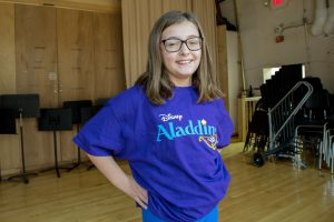 An elementary girl in an Aladdin t-shirt