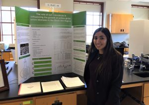 Student poses in front of her science research display