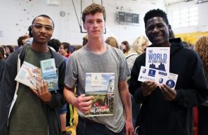 Three students with college materials