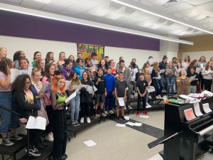 High school and middle school students singing together in a music room